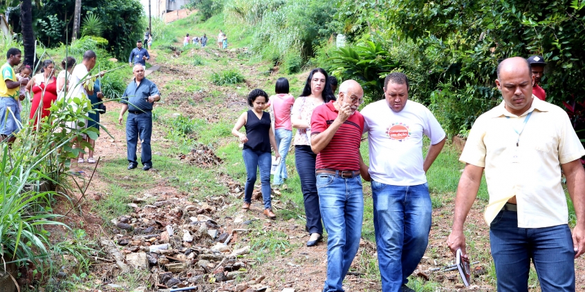 Vereador, convidados e moradores descem rua íngreme, em terra batida