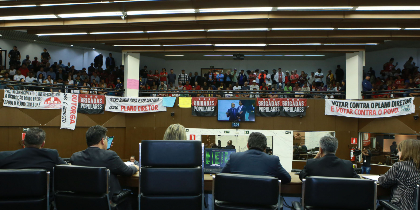 Vista da galeria do Plenário. Cheia de manifestantes. Faixas defendem a aprovação do Plano Diretor
