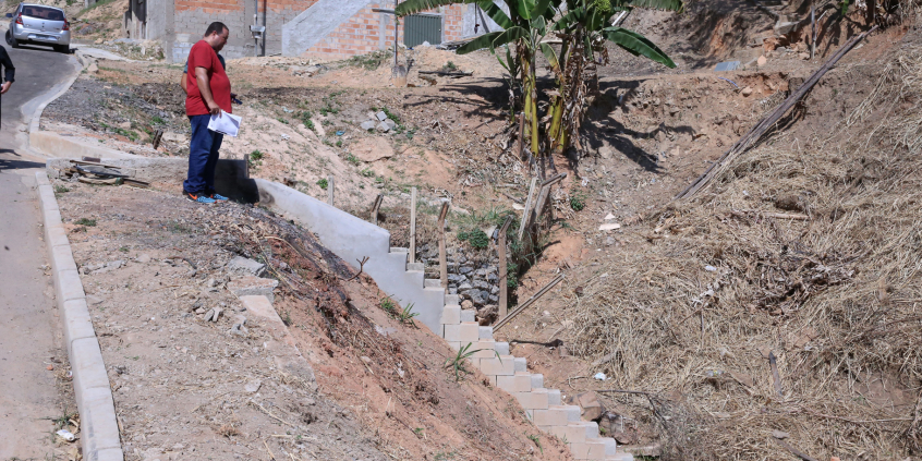 Escadaria construída em cimento liga o nível da rua ao vale do rio. Vereador avalia a obra do topo da escada