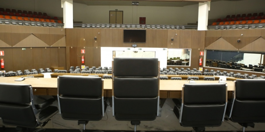 Imagem mostra o Plenário Amynthas de Barros; em primeiro plano, veem-se as costas das cadeiras da Mesa Diretora voltadas para o plenário e as galerias vazios
