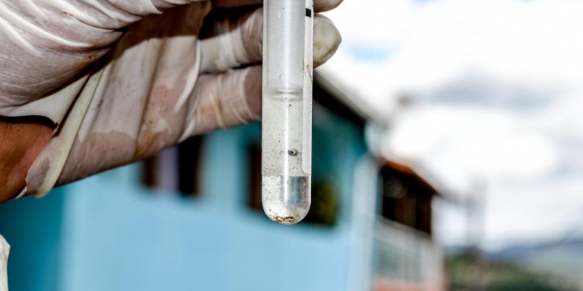 Mão com luva segura tubo de ensaio