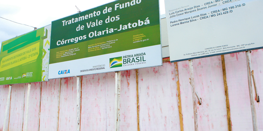 Placa informativa em frente à obra pública.