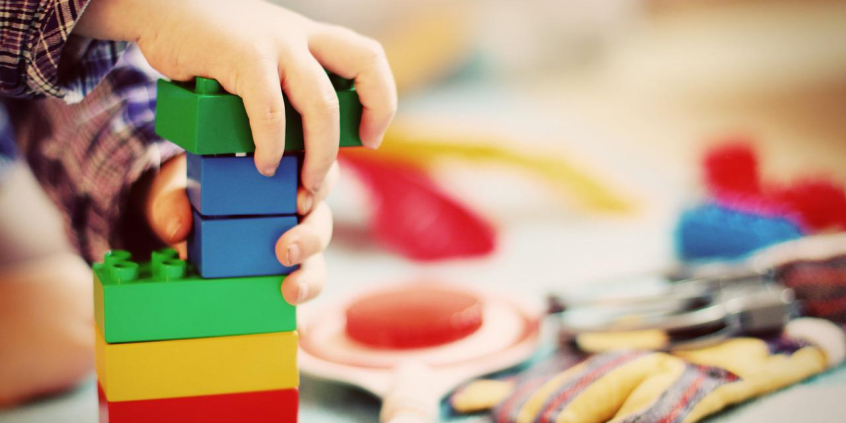 Mãos de criança brincando com peças de montar