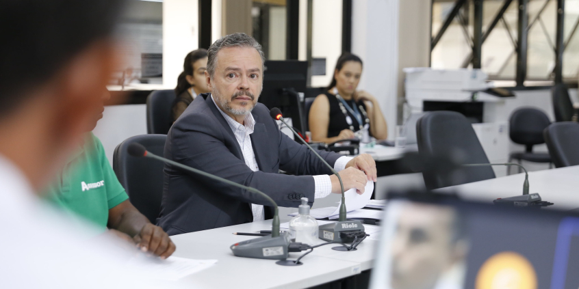 Imagem do subsecretário Eugênio Veloso sentado à mesa diante dos vereadores.