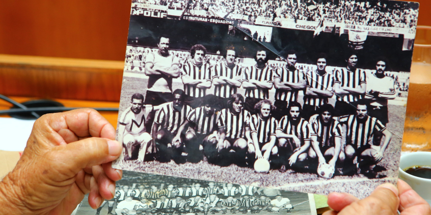Foto mostra mãos segurando foto antiga de clube de futebol