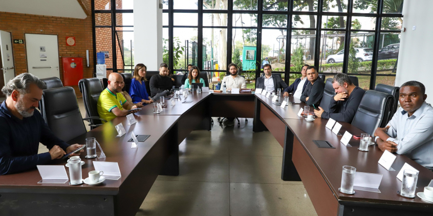 Dez parlamentares em reunião, sentados à mesa, no Hall da Presidência.