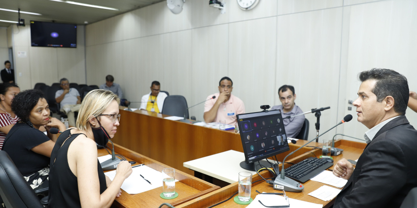 Sete pessoas reunidas, sentadas à mesa.