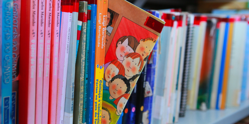 Livros didáticos em prateleira de biblioteca