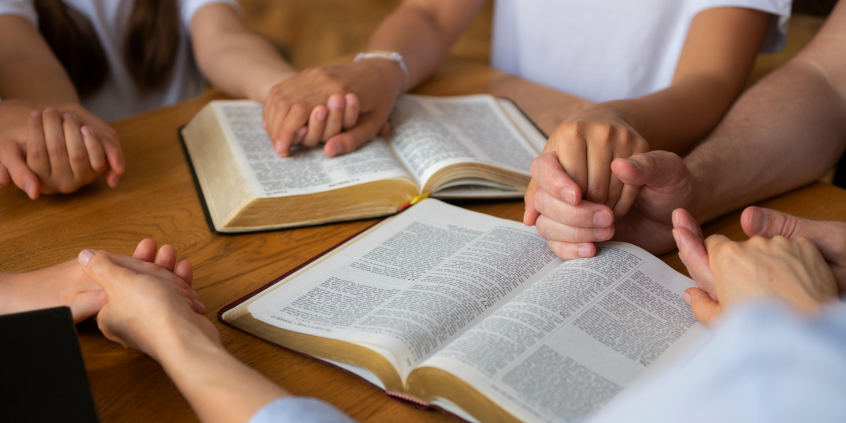 A foto retrata um momento de leitura da Bíblia