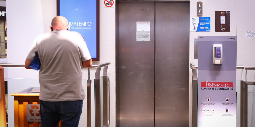 homem parado a frente de elevador
