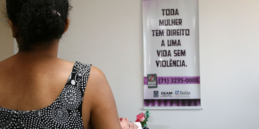 mulher de costas em frente a um cartaz