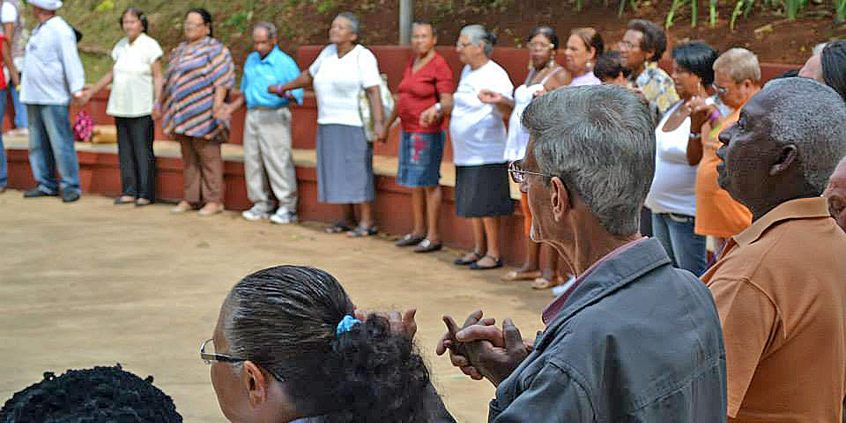grupo de idosos em roda dando as mãos