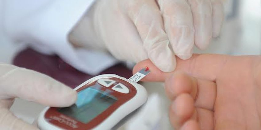 pessoa realiza aferição de glicose em equipamento portátil