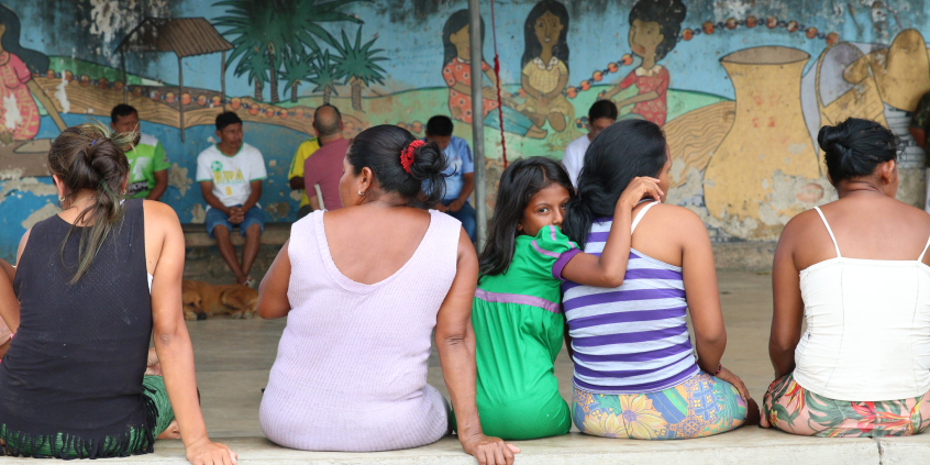 grupo de mulheres sentadas em banco, vistas de costas