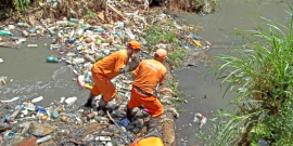 Agentes da Prefeitura retirando lixo de córrego poluído