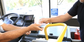 Motorista de ônibus cobrando passagem de um passageiro
