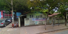 Fachada do Centro de Saúde Santa Rosa. Placa indicativa parcialmente coberta pela copa das árvores