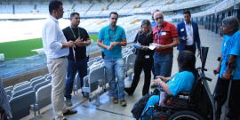 vereador e convidados em visita ao Mineirão. Gramado e arquibancada ao fundo