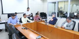 Os cinco membros titulares da comissão estão sentados à Mesa, apreciando a pauta da reunião que i