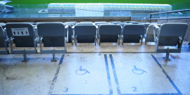 sinalização no chão em área reservada para cadeirantes em arquibancada no estádio de futebol. Vista do campo ao fundo