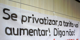 Faixa afixada na parede do plenário com a inscrição "Se privatizar, a tarifa vai aumentar! Diga não!"