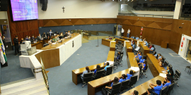 Plenário visto do alto. É possível ver a mesa com os vereadores e as cadeiras ocupadas por adolescentes que participaram da audiência