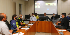 Os vereadores Wesley e Braulio em sala de reunião, acompanhados de quatro cidadãos, todos sentados à mesa e com máscara.