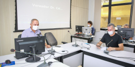 Dois veradores em reunião, ao fundo, dois assessores da Câmara. 