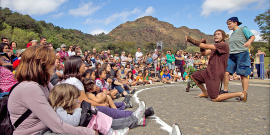 Apresentação teatral feita na rua com dois atores e mais de 50 espectadores, durante o dia. 