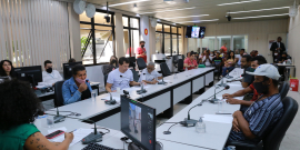 Imagem da sala de reunião com diversos participantes 