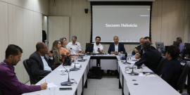 Oito homens e três mulheres sentados à mesa, conversando. 