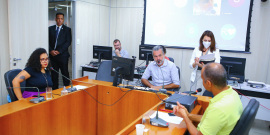 Imagem dos vereadores em reunião, sentados em torno de uma mesa em U 