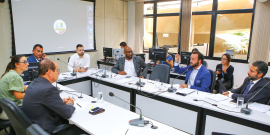 Imagem da reunião. Participantes sentados em mesa em formato de U