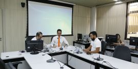 Três vereadores participam de reunião, sentados à mesa.