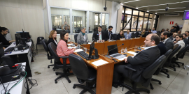 Imagem da sala de reunião identificando os vereadores e especialistas que compõe a mesa e o público que acompanha a audiência 