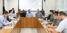 Quatro parlamentares e seis cidadãos e representantes do Município e de empresa, sentados à mesa, em reunião