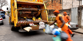 Foro de garis recolhendo lixo doméstico e colocando no caminhão de coleta