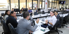 três parlamentares acompanham depoente, ao lado de seu advogado, em reunião.