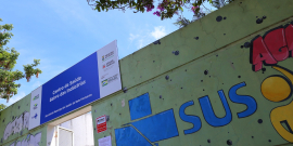 fachada do Centro de Saúde Bairro das Indústrias, com a logo do SUS pintada, durante o dia.te o dia