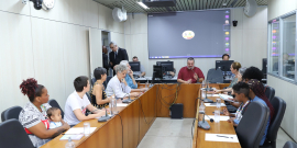 IMagem do Plenário Camil Caram durante a reunião. Pedro Patrus está sentado na cabeceira da mesa repleta de convidados