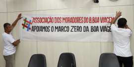 Imagem de faixa fixada na parede do Plenário com os seguintes dizeres: Associação de Moradores apoiam o Marco ZEro na Igreja da Boa Viagem 