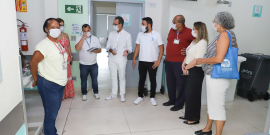 Oito pessoas de pé, reunidas no interior do Hospital Metropolitano Odilon Behrens, durante o dia.