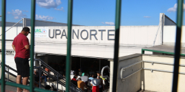 Imagem da fachada da UPA Norte por trás das grades da entrada