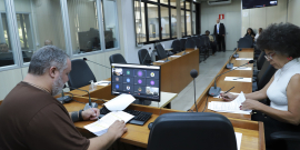 Dois parlamentares em reunião, sentados à mesa.