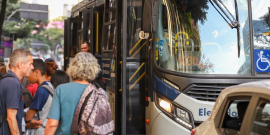 imagem da frente de um ônibus com pessoas entrando e em pé na porta