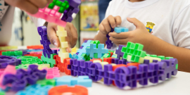 Criança mexe com brinquedo de montar em sala de aula