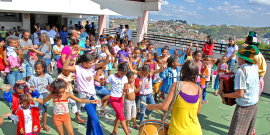 crianças dançam e assistem à apresentação de música