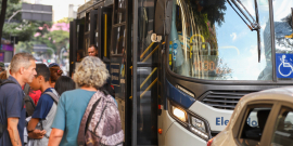 Pessoas entrando e saindo de ônibus
