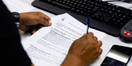 Mão segura pauta da reunião da Comissão de Orçamento e Finanças Públicas