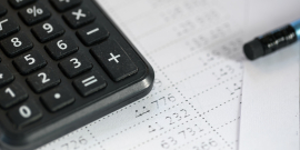 Calculadora sobre papel com lápis ao lado